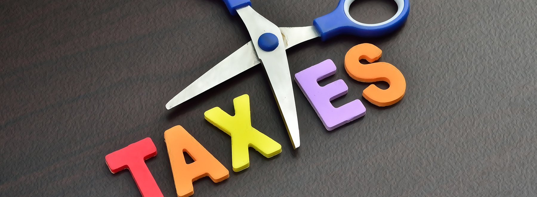 Cut Your Taxes, abstract image showing the word tax being cut in two, symbolic of tax reductions.