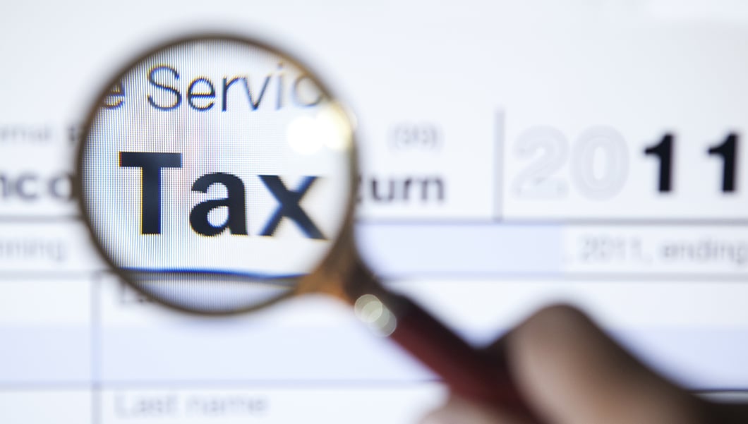 Tax E-News October 2015, Tax magnified on document by magnifying glass.